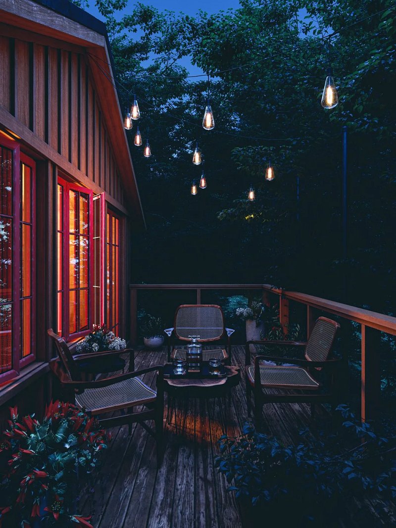 Wooden outdoor seating beneath string lights at twilight