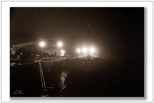 Night shift on the Puget Sound. A Crowley tug holds steady alongside a barge as the work continues beneath the glow of deck l...