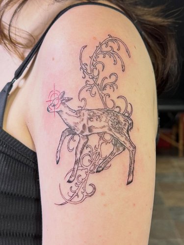 The fawn often symbolizes gentleness and vulnerability, while the surrounding ornamental linework acts as a protective, chaot...