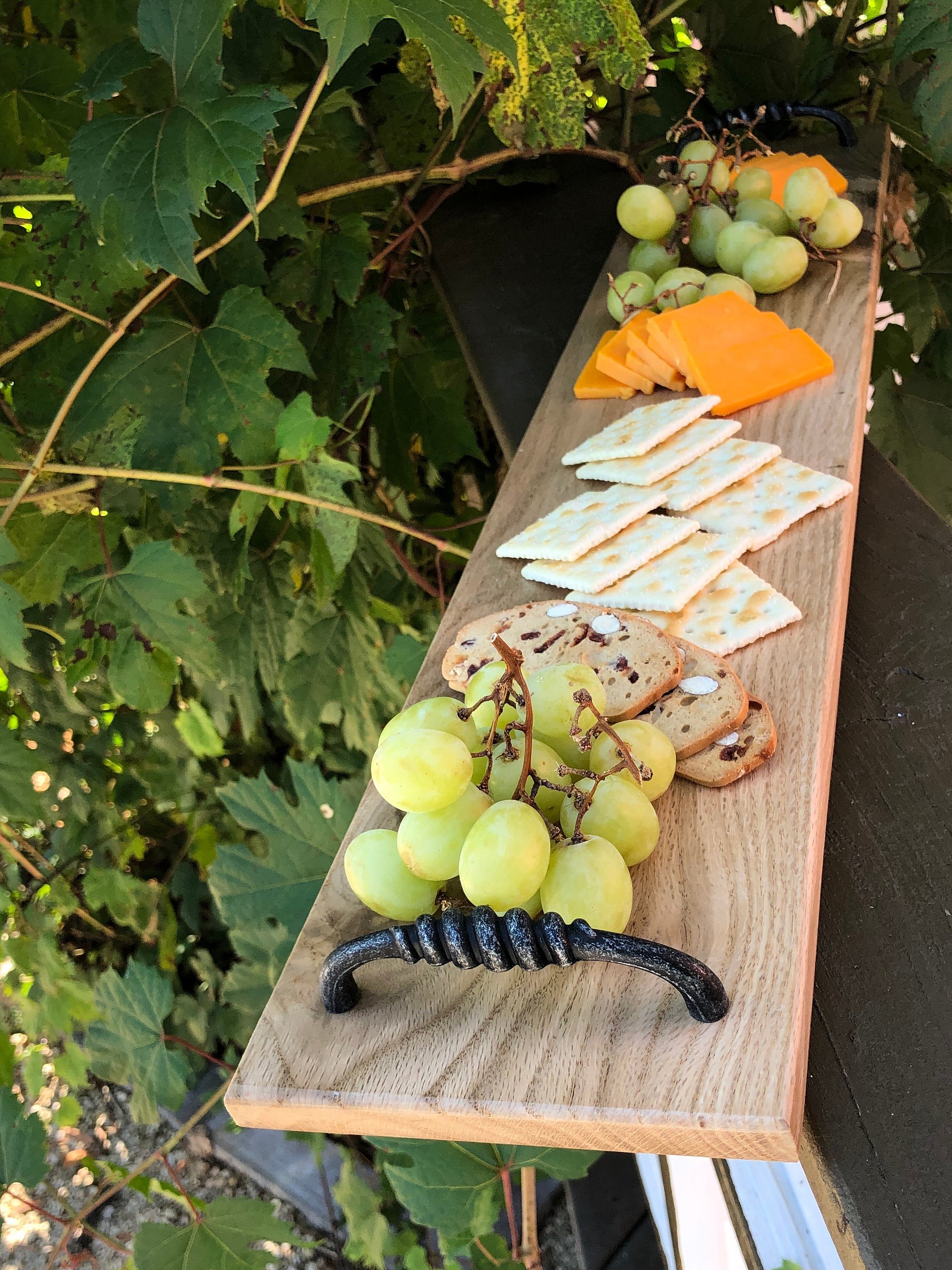 Knotty oak wood and wine red resin charcuterie board,cheese board, 5 1/2" x 27" x 5/8", with 4" twisted black handles. product image (1)