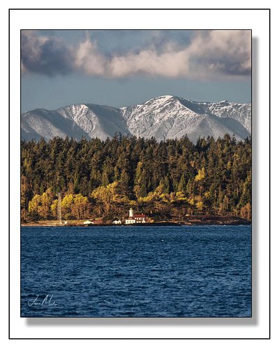 Point Wilson Lighthouse sitting beneath fresh snow on the Olympic Mountains—one of those clear Pacific Northwest days where
W...