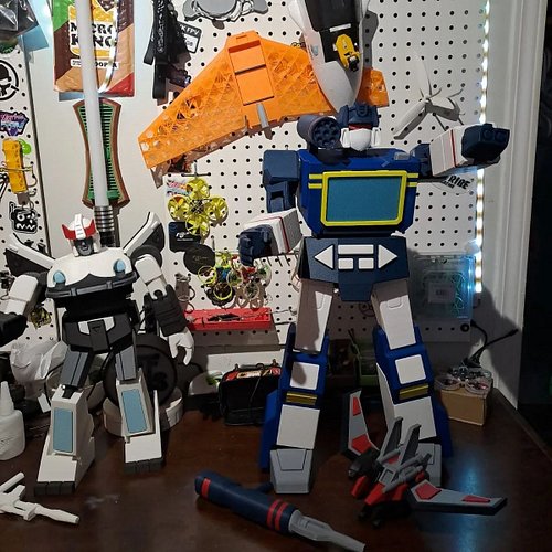 Soundwave standing with his tape deck and lazerbird