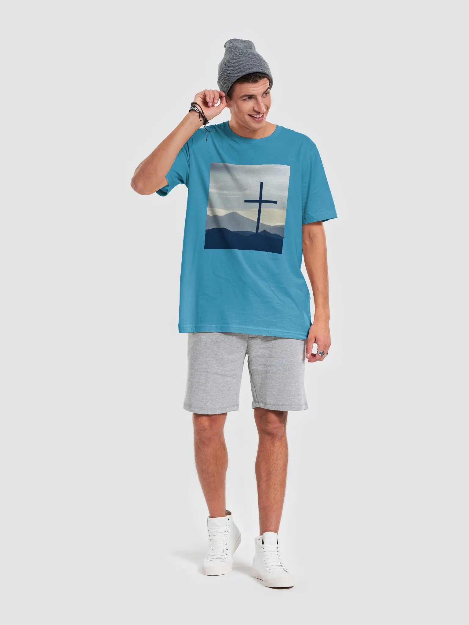 A cross standing against a serene landscape of rolling hills and distant mountains under a soft, cloudy sky t-shirt product image (6)