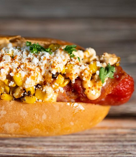 The Elote Dog has become one of our top dogs!  A bacon-wrapped dog with fire roasted corn, chipotle lime mayo, cotija cheese ...