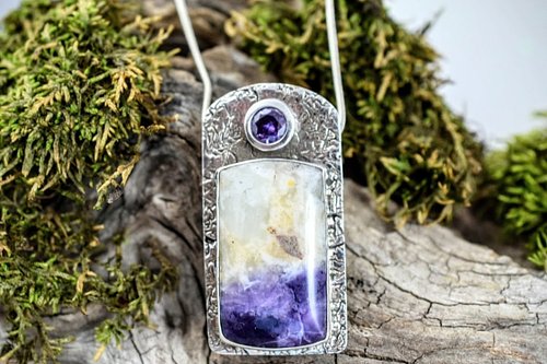 This stunning sterling silver pendant showcases a captivating purple opal cabochon, radiating vibrant hues that shift with th...