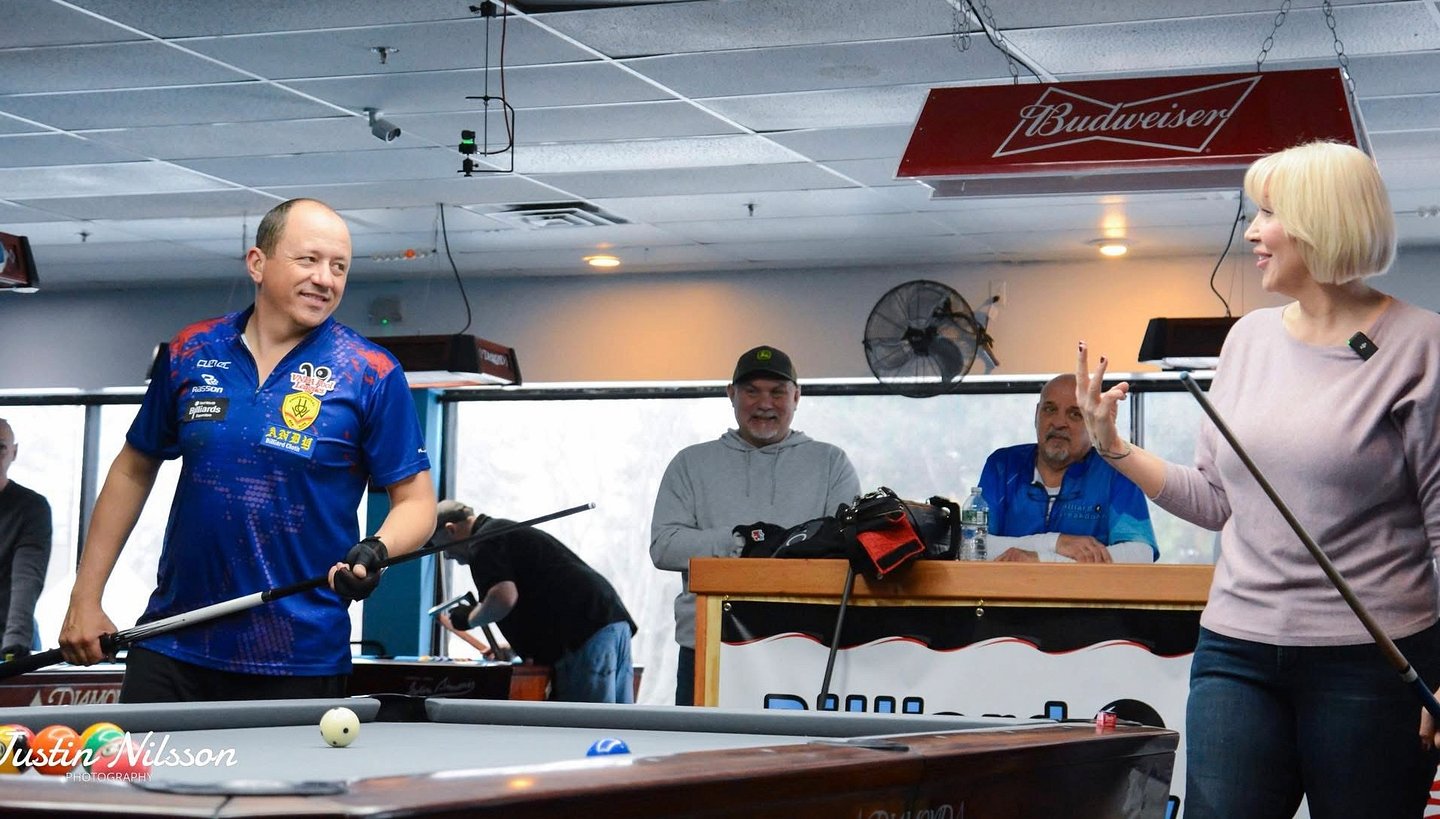 Christine sharing a fun moment at the pool table with professional billiards player Shane Van Boening