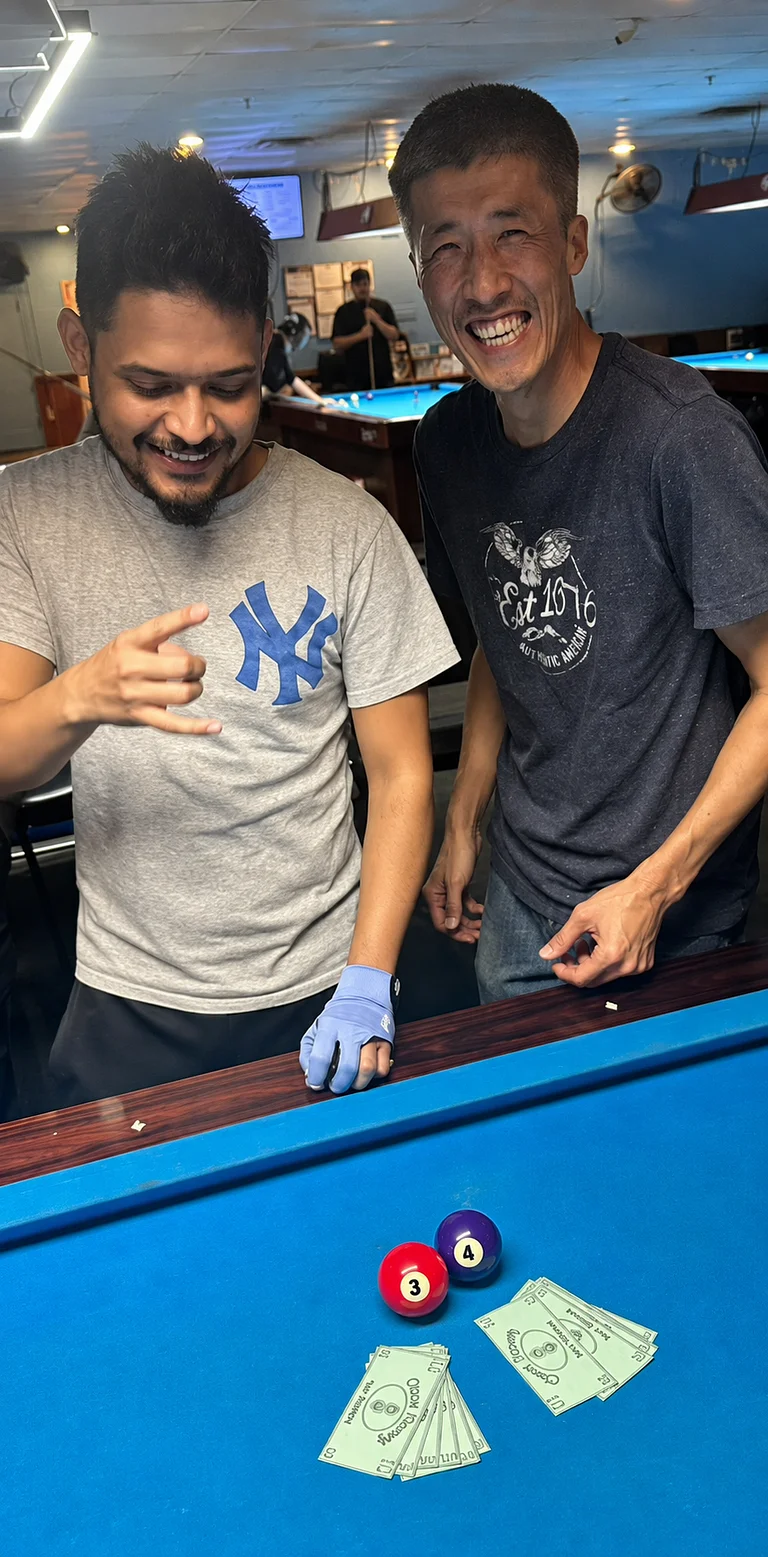 Jason and Mike smiling after being surprised with play money instead of their expected tournament winnings