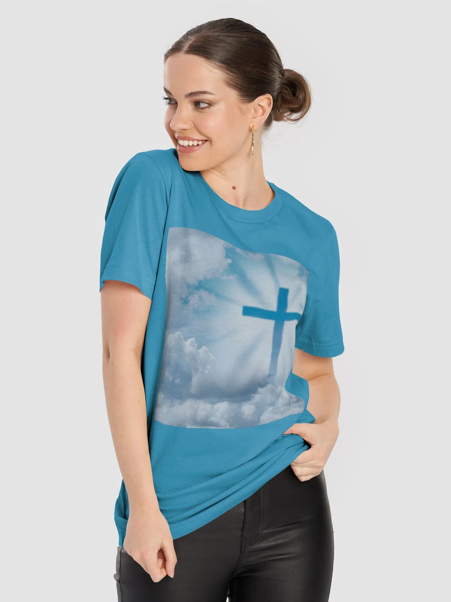 A cross surrounded by a heavenly scene, with rays of light shining through soft clouds in a bright blue sky t-shirt product image (9)