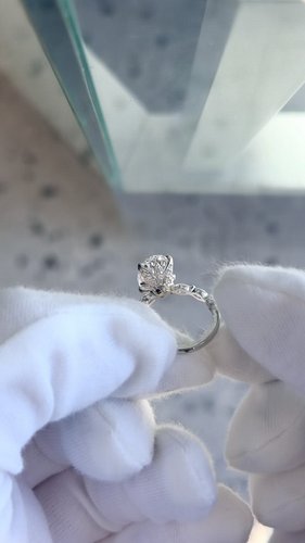 Timeless elegance meets intricate craftsmanship. Featuring a 3.15ct oval brilliant diamond, designed with a diamond set tulip...