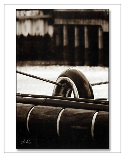 The bow of the Tug Athena up close — tow staple, bow lines crossing, rubber fendering worn smooth by working lines. Sepia tur...