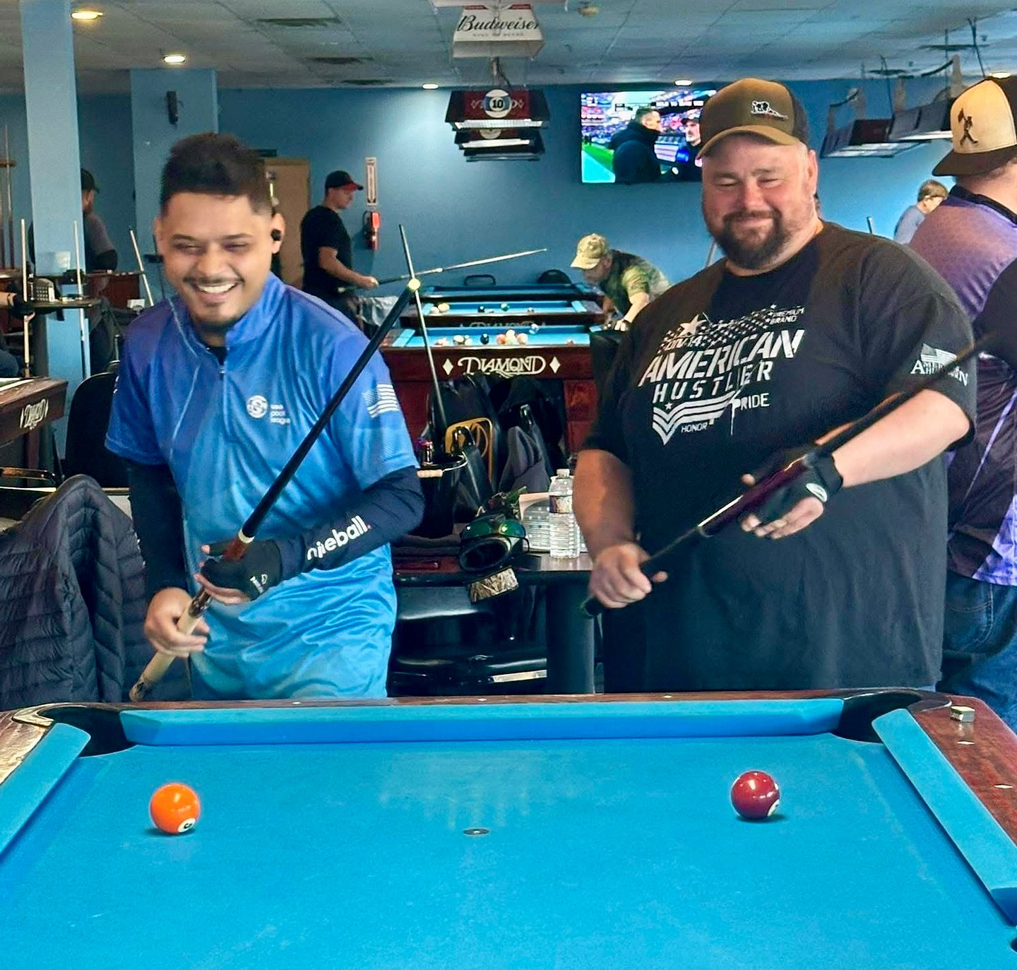 Two Check My Rack pool players laughing together during tournament play