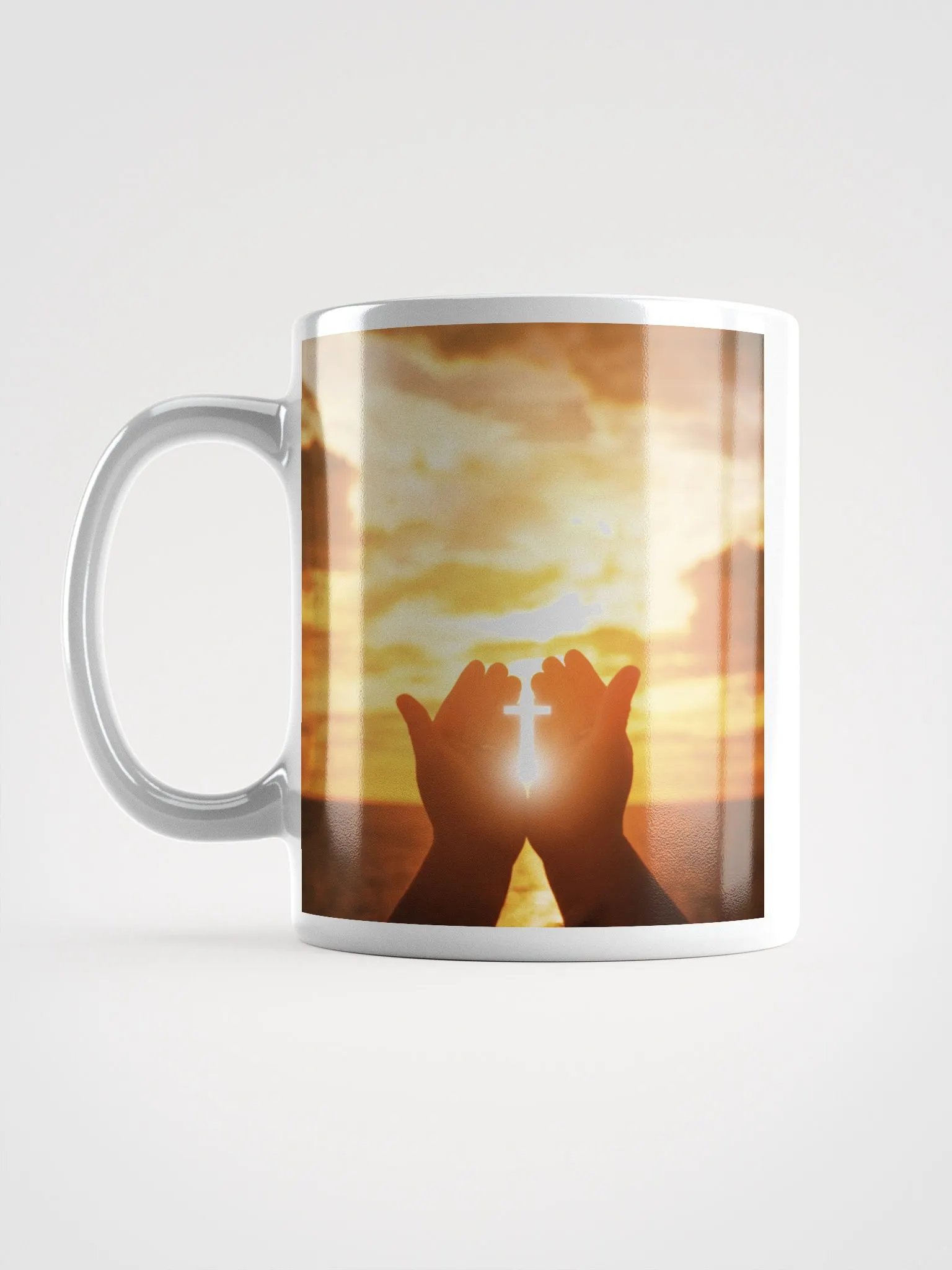 Cupped hands holding a glowing cross silhouette & Wooden cross being held up against the backdrop of a sunrise Mug product image (2)