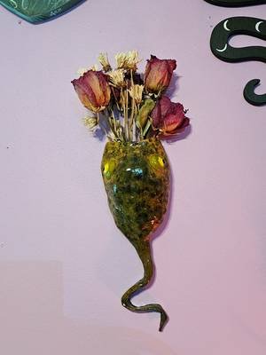 this tadpole stores my dry roses for me! he's made of air-dry clay, paint, and a dream ✨🥀 this was my first time making a wall pocket or really any sculpture, and I'm pleased as punch, as the old biddies say. I want to make a heart one for my wedding bouquet 💐 honestly, my first idea for this was a dead bird, so maybe a tadpole was for the best?  #tadpole #froglovers #wallpocket #driedflowers #driedroses 