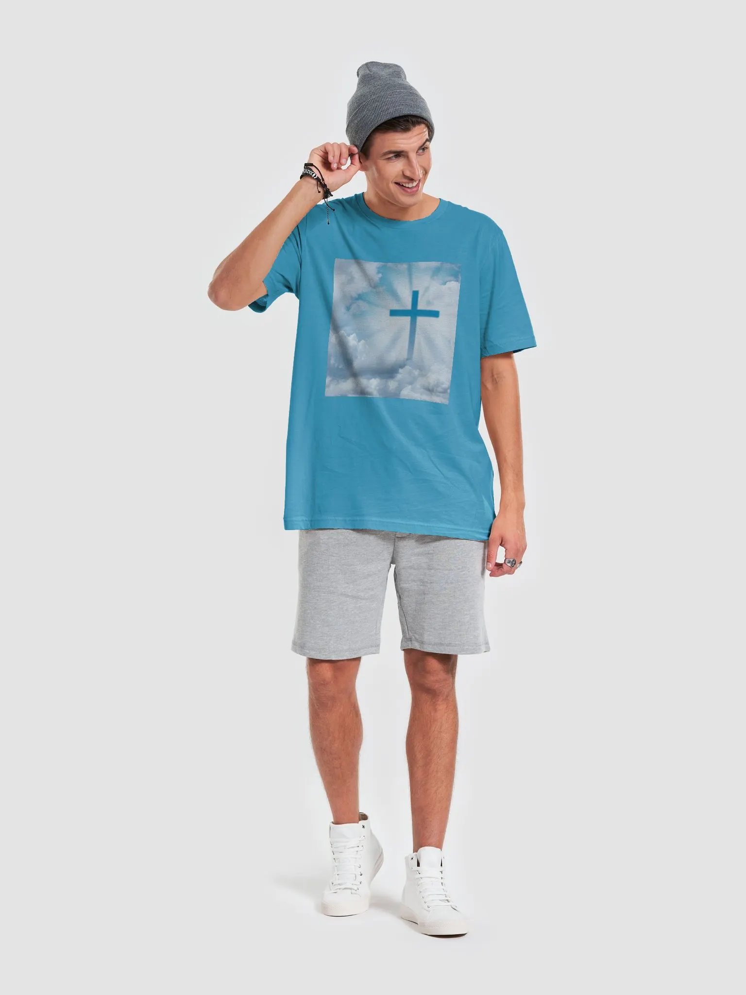 A cross surrounded by a heavenly scene, with rays of light shining through soft clouds in a bright blue sky t-shirt product image (7)