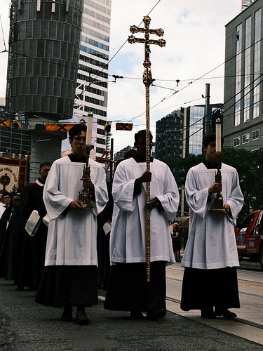Sunday afternoon, downtown Toronto: the Church carried Christ past the hospital doors and the glass towers.
This is Corpus Ch...