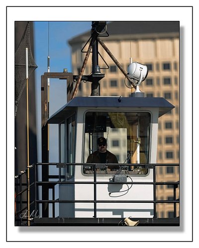 Eyes on the water. The captain of Tug AJ keeps watch from the upper wheelhouse while working barges in Seattle Harbor — downt...