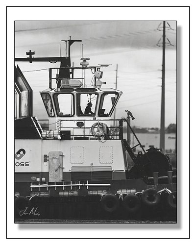Foss captain silhouetted in the wheelhouse, working a ship in the Port of Tacoma. That lone figure against the glass says eve...