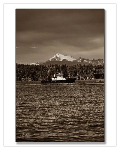 Tug Valor working an escort in Guemes Channel — Mt. Baker absolutely dominating the sky behind her in sepia. Small tug, big m...