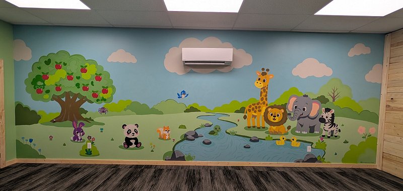 Completed church nursery mural featuring illustrated animals and a river landscape