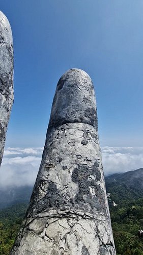 Standing on Rainbow Bridge at Ba Na Hills 🇻🇳 and looking through the giant stone hands at cable cars crossing the mountains.
...