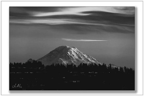Mt. Rainier and a lenticular cloud at evening light — black and white strips it down to pure form and drama. The mountain doe...