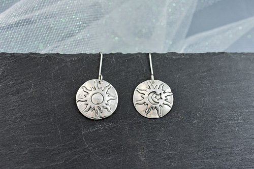 Raw energy meets celestial calm in these bold sterling silver earrings. One side features the blazing sun in its full, fiery ...